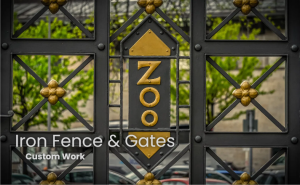 custom wrought iron gate in black with iron emblem that spells zoo vertically and emblazoned with a gold coating at the entrance of a Texas commercial business