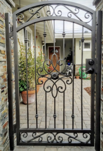 classic custom wrought iron gates with detailed scrollwork at the back garden and walkway of a house in Longview, Texas