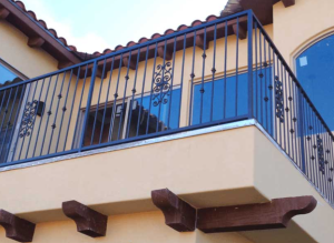 custom wrought iron balcony railing on the second story of mediterranean style house with tiled roof