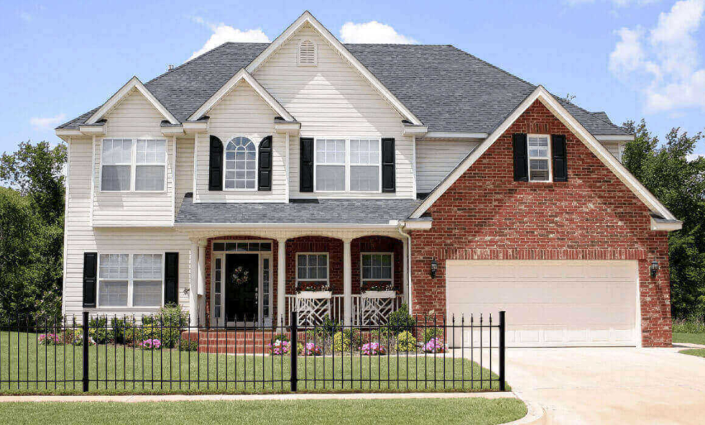 Beautiful East Texas home with a hip high wrought iron fence across the front adding curb appeal