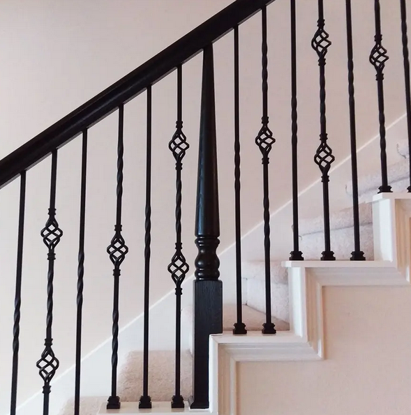 custom wrought iron handrail on an interior staircase in east texas home. It has black spindles with scrollwork design
