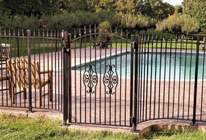 custom wrought iron pool fence and gate with decorative ironwork on the gate surrounding a below ground pool in Longview, Texas